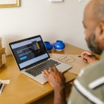 Empreendedor usa um laptop à mesa para planejar atividades do negócio.