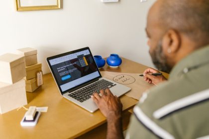 Empreendedor usa um laptop à mesa para planejar atividades do negócio.