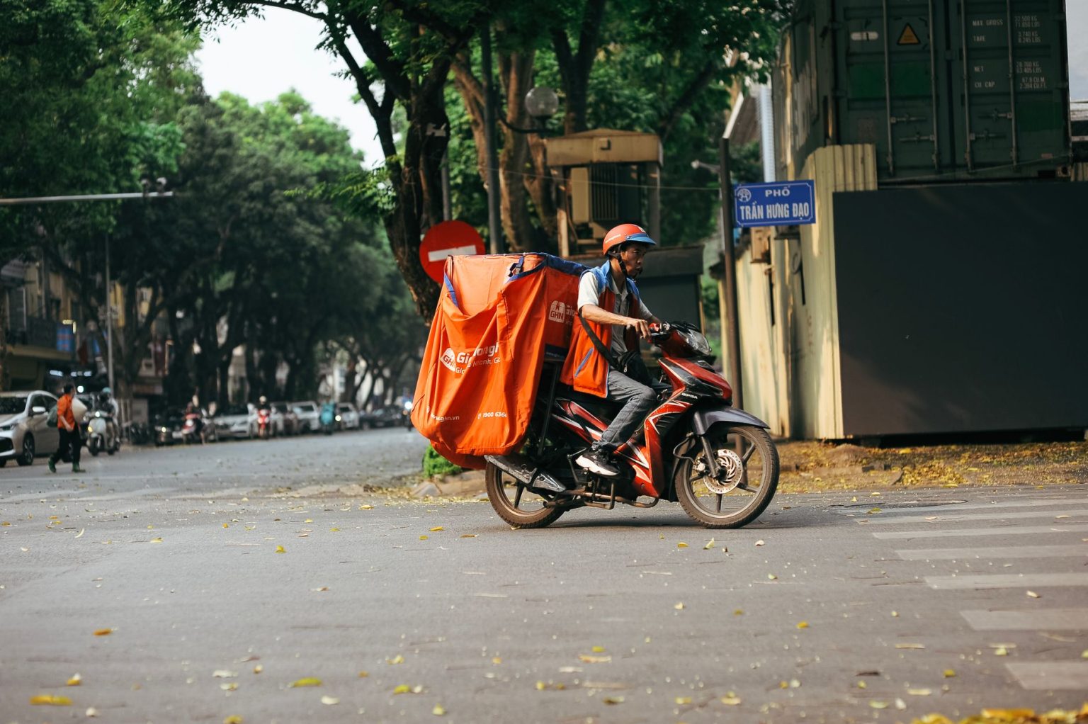 Entregador profissional transporta mercadorias em uma motocicleta por uma rua movimentada da cidade.